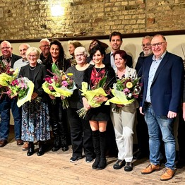 Eine Gruppe von Männern und Frauen, einige mit Blumenstraußen, strahlen in die Kamera. (Bild: LWL)