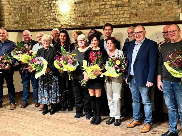 Eine Gruppe von Menschen, die Frauen mit Blumensträußen, strahlt in die Kamera (Bild: LWL)
