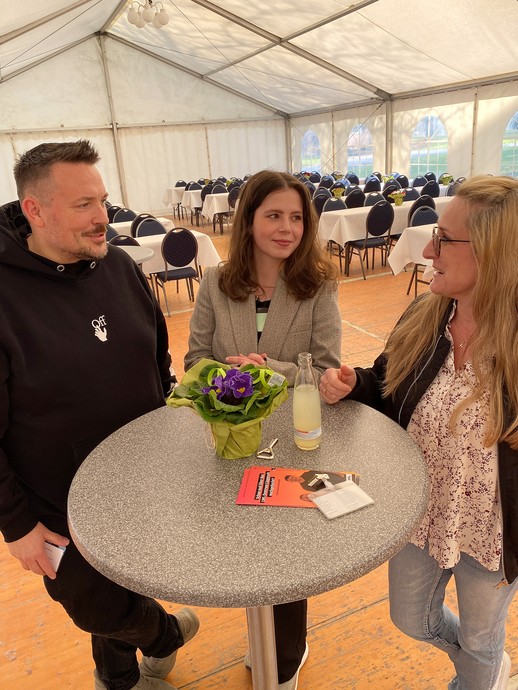 Ein Mann und zwei Frauen unterhalten sich an einem Stehtisch in einem Festzelt (Foto: LWL/SchuFi) (vergrößerte Bildansicht wird geöffnet)