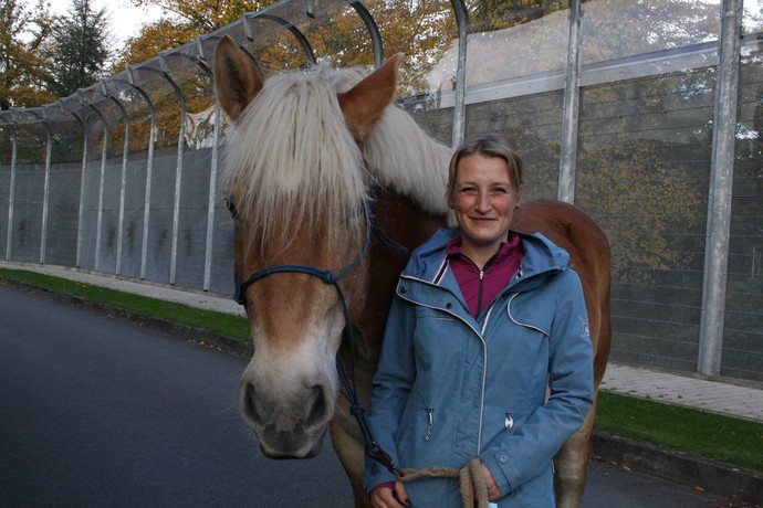 Das karamellfarbene Pferd und die Frau schauen nebeneinander in die Kamera.