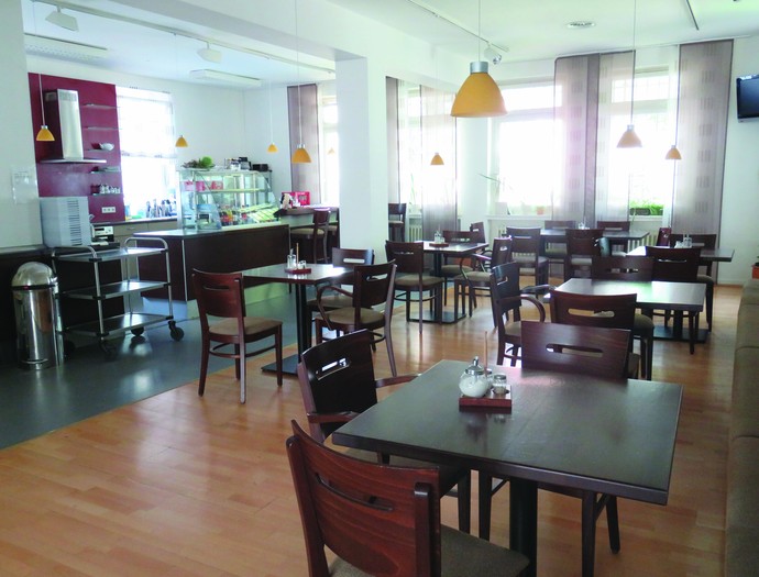Blick in ein Café mit Theke und Bistrotischen (Foto: LWL)