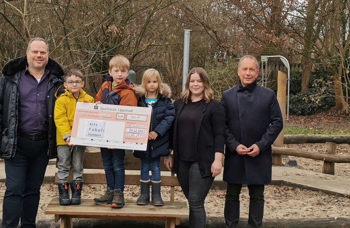 Zwei Männer, eine Frau und mehrere Kinder präsentieren einen großen Scheck. Bild: LWL/Goy