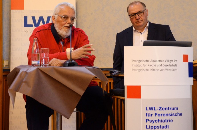 Zwei Männer sitzen bzw. stehen an einem Rednertisch (Foto: Institut für Kirche und Gesellschaft)