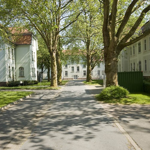 Ein Weg zwischen weißen Gebäuden (Foto: LWL) Ein Weg zwischen weißen Gebäuden (Foto: LWL)