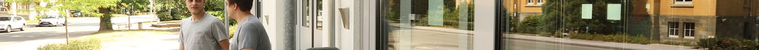 Zwei junge Männer verlassen nebeneinander die Pforte. (Bild: LWL/Wieland).