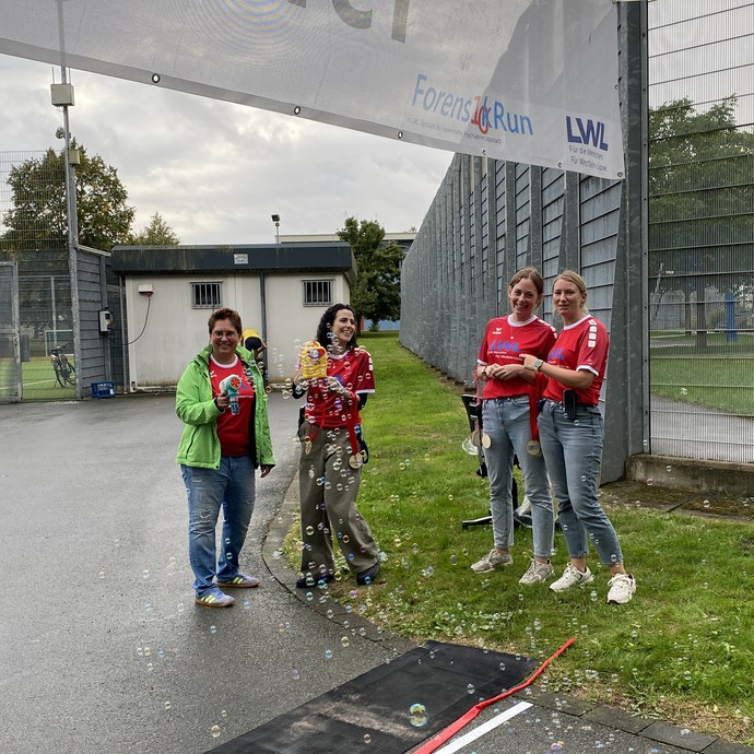 Frauen in roten LWL-Trikots mit einer Seifenblasenmaschine (Bild: LWL/Schufi) (vergrößerte Bildansicht wird geöffnet)