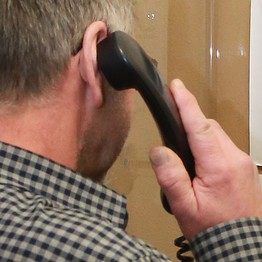 Jemand telefoniert mit einem Festnetztelefonhörer (Bild: LWL)