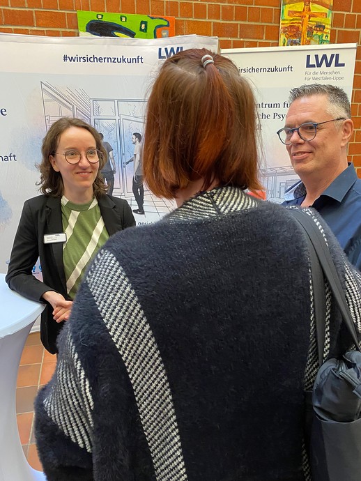 Mehrere Personen an einem Infostand (Foto: LWL/SchuFi) (vergrößerte Bildansicht wird geöffnet)