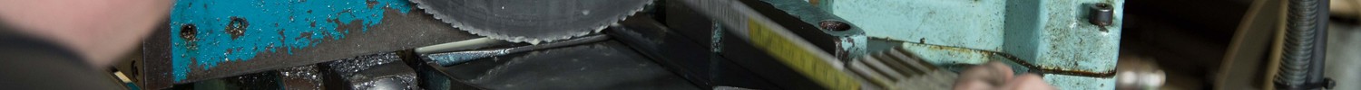 Jemand misst mit einem Zollstock ein Metallwerkstück in einer Maschine aus. (Bild: LWL)